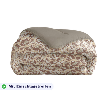 Gefaltete Decke mit Camouflage-Muster, einfarbig taupefarbenem Rand, beschriftet mit Einschlagstreifen und Karomuster - dieses Zelesta Royalbed - Sand Panther ist auch eine Anti-Allergie-Decke.
