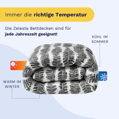 Abgebildet ist ein gefaltetes Zelesta Wonderbed - Savanna Feather mit einem schwarz-weißen Blattmuster; der kommentierte Text hebt hervor, dass es im Winter warm und im Sommer kühl hält.