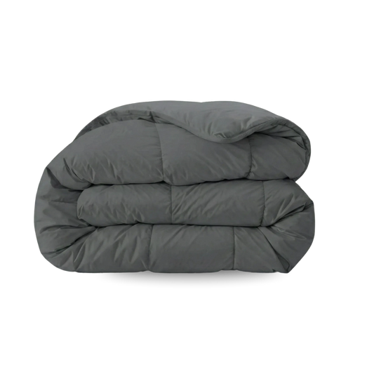 Das Zelesta Wonderbed - Stone Grey ist eine dunkelgraue, gefaltete Bettdecke mit Steppmuster, die auf einem einfarbig weißen Hintergrund abgebildet ist.