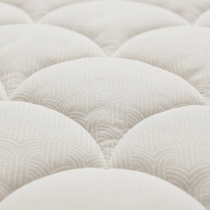 Nahaufnahme der Zelesta Flanel Luxe - Creme: eine weiße, gesteppte Matratzenoberfläche mit dezentem geometrischem Muster und geschwungenen, gepolsterten Partien - ideal zur Kombination mit dieser temperaturregulierenden Bettdecke für optimalen Schlafkomfort.