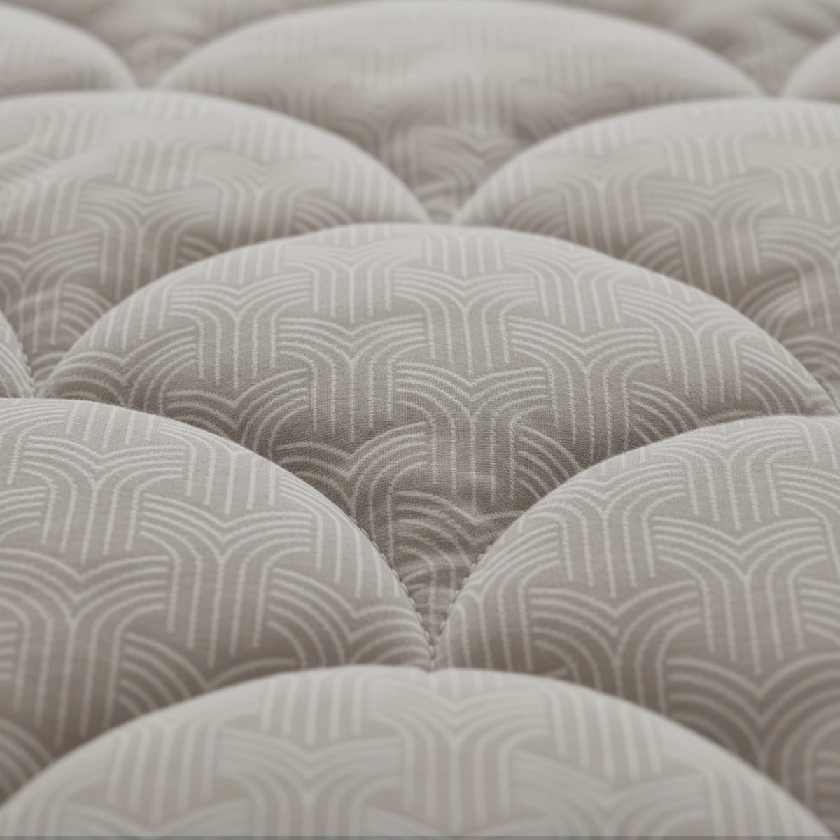 Nahaufnahme der Zelesta Flanel Luxe - Taupe & Grey Matratzenoberfläche mit getufteten Kreisen und einem geometrischen Muster in Beige und Weiß, ideal zur Kombination mit einer temperaturregulierenden 2-in-1-Bettdecke für ganzjährigen Komfort.
