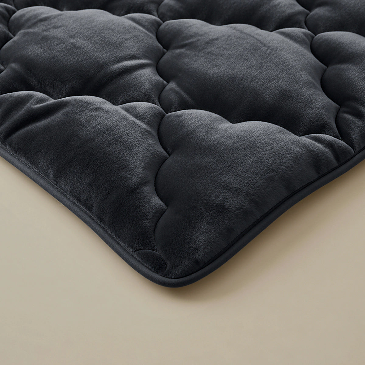 Nahaufnahme der Zelesta Flanel Uni - Schwarz Matratzenauflage in Dunkelgrau mit einer plüschigen, samtigen Textur - perfekt für zusätzlichen Komfort in Kombination mit einer temperaturregulierenden Mikrofaser Bettdecke.