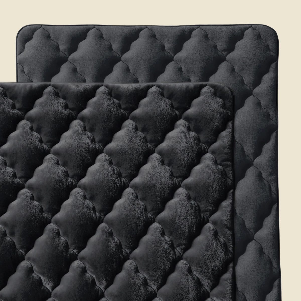 Zelesta Flanel Uni - Schwarz: Zwei überlappende schwarze Steppmatten - eine mit samtartigem Rautenmuster, die andere glatt - vor beigem Hintergrund, perfekt als ganzjährig temperaturregulierende Mikrofaser oder Flanel Bettdecke.