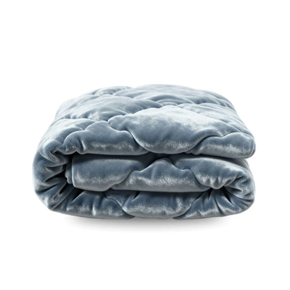 Die Zelesta Flanel Uni - Blue Mirage, eine gefaltete, gesteppte hellblaue Mikrofaser-Bettdecke, ist vor einem weißen Hintergrund abgebildet.