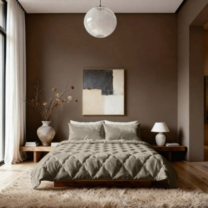 Ein modernes Schlafzimmer mit einer Zelesta Flanel Uni - Taupe Bettdecke auf einem niedrigen Bett, abstrakter Wandkunst, einer runden Deckenleuchte und einer minimalistischen Dekoration mit einer Vase mit getrockneten Zweigen und einer Tischlampe.