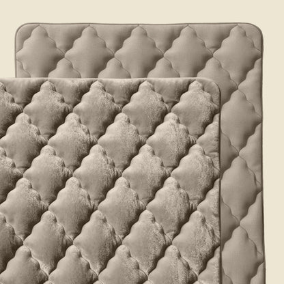 Zwei gesteppte rechteckige Matten überlappen sich und zeigen eine rautenförmige, gepolsterte Textur in neutralem Taupe - perfekt als Zelesta Flanel Uni - Taupe Mikrofaser Bettdecke für zusätzlichen Komfort und Weichheit.