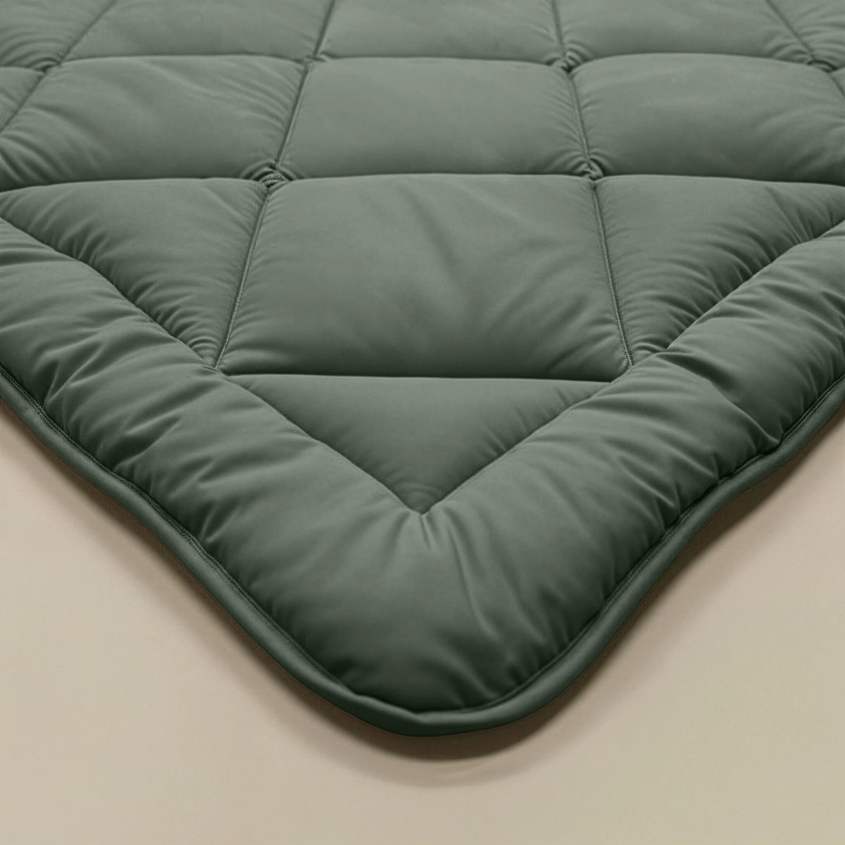 Nahaufnahme der gesteppten Matratzenauflage Zelesta Royalbed Diamant - Grün mit Rautensteppmuster auf einer hellen Oberfläche, die für Komfort und Frische sorgt.