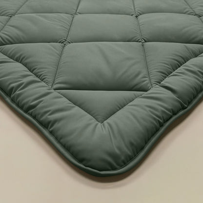 Nahaufnahme der gesteppten Matratzenauflage Zelesta Royalbed Diamant - Grün mit Rautensteppmuster auf einer hellen Oberfläche, die für Komfort und Frische sorgt.