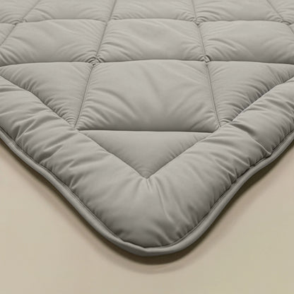 Eine Nahaufnahme zeigt die sand-beige, gesteppte Zelesta Royalbed Diamant, die mit ihrer abgesteppten, wattierten Struktur und den Eckdetails die perfekte temperaturregulierende Bettdecke darstellt.