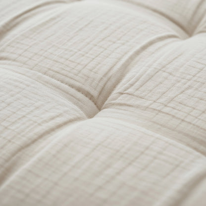 Nahaufnahme von Zelesta Teddy Baumwolle Musselin - Beige, mit gestepptem cremefarbenem Stoff mit sichtbaren Nähten und weicher, temperaturregulierender Tufting-Polsterung.