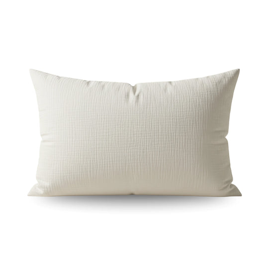 Ein rechteckiges weißes Kissen mit einem subtilen Strukturmuster, das vor einem schlichten weißen Hintergrund gezeigt wird. Perfekt zu kombinieren mit unserem Teddy Baumwolle Mousseline Kissenbezüge Set von 2 - Beige für ein stilvolles Arrangement.