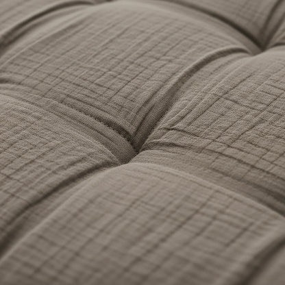 Nahaufnahme eines beigen, getufteten Stoffkissens mit sichtbaren Nähten - perfekt zur Kombination mit Ihrem Zelesta Teddy Baumwolle Musselin - Taupe für gemütlichen Komfort.