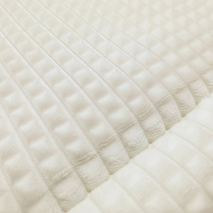 Nahaufnahme des Zelesta Teddy Check - Créme mit weißem, strukturiertem Stoff mit einem gesteppten, gitterartigen Muster und erhabenen, parallelen Linien.