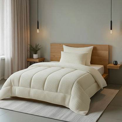 Ein ordentlich gemachtes Bett mit der Bettdecke Zelesta Teddy Check - Créme, einem Kopfteil aus Holz, zwei Pendelleuchten, Beistelltischen und einer Topfpflanze in einem minimalistischen Schlafzimmer.