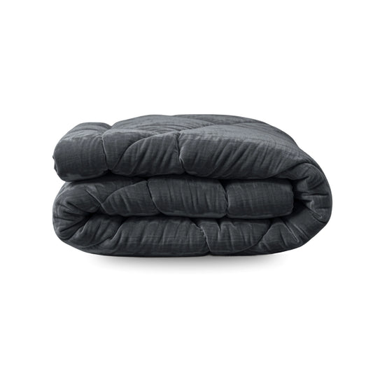 Eine fein säuberlich gefaltete Zelesta Flanel Velvetbed Chique-Gewichtsdecke in Anthrazit ruht auf einem schlichten weißen Hintergrund.