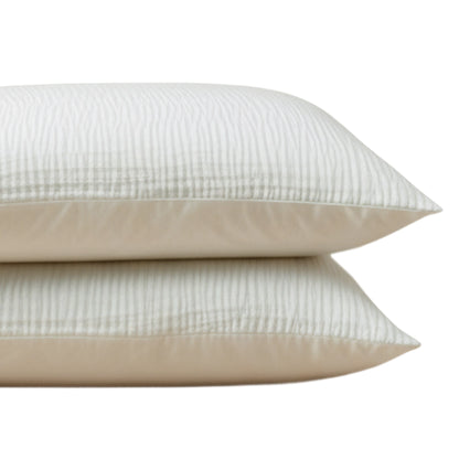 Zwei beigefarbene, gestreifte Kissen auf weißem Hintergrund, mit Zelesta Velvetbed Chique Kissenbezügen Set von 2, hergestellt aus weichem Polyester für ein luxuriöses Gefühl.