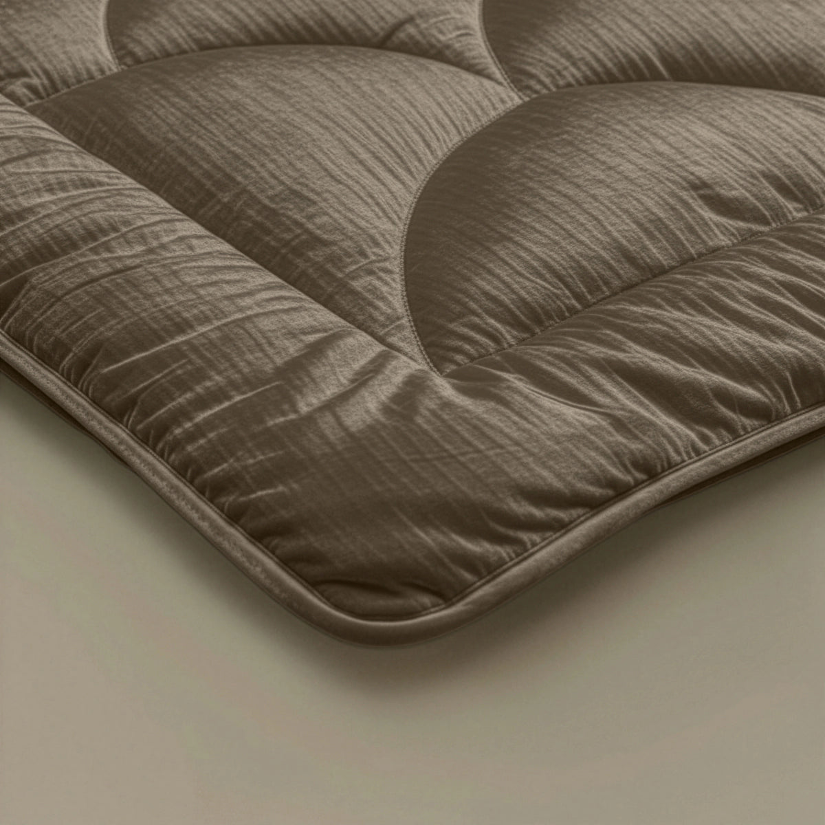 Nahaufnahme des Zelesta Flanel Velvetbed Chique - Taupe, die die braunen Steppnähte und die weiche, luxuriöse Stofftextur hervorhebt.