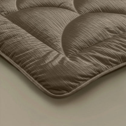 Nahaufnahme des Zelesta Flanel Velvetbed Chique - Taupe, die die braunen Steppnähte und die weiche, luxuriöse Stofftextur hervorhebt.