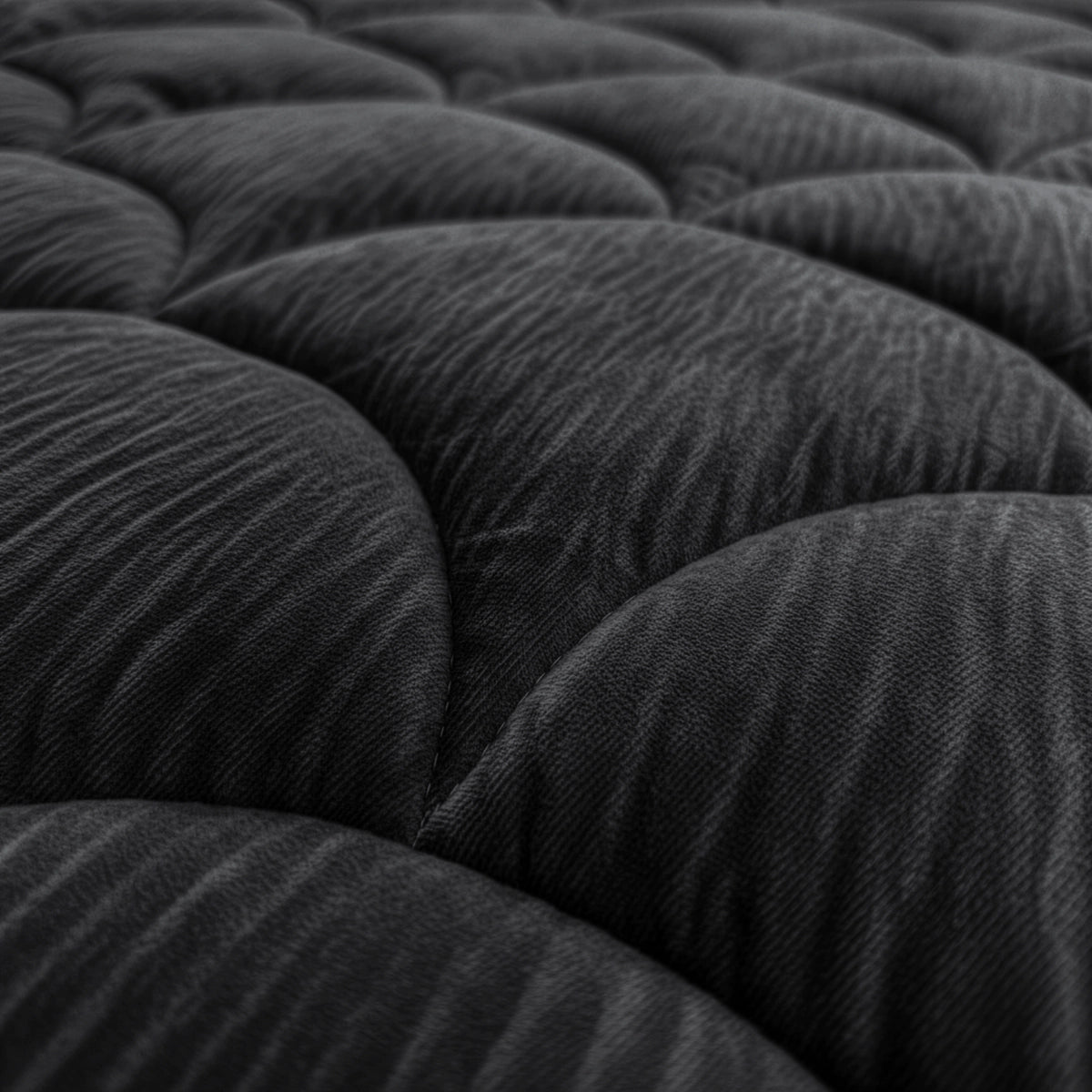 Die Nahaufnahme der dunklen, strukturierten, gesteppten Oberfläche mit geschwungenen, gepolsterten Abschnitten unterstreicht das elegante Design des Zelesta Flanel Velvetbed Chique - Black, ideal für ein luxuriöses Schlafzimmer.